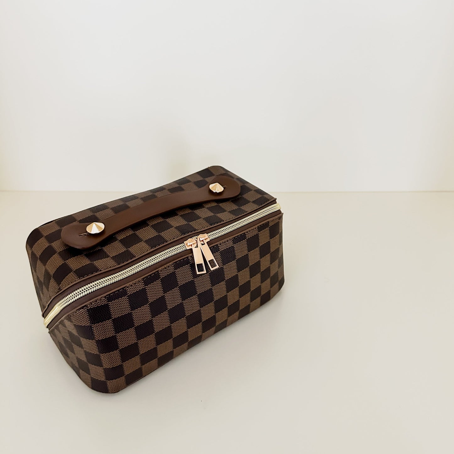 Brown checkered toiletry case holds makeup, skincare, perfume and more