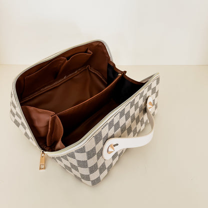 Checkered pattern zippered toiletry case zippers open and lays completely flat