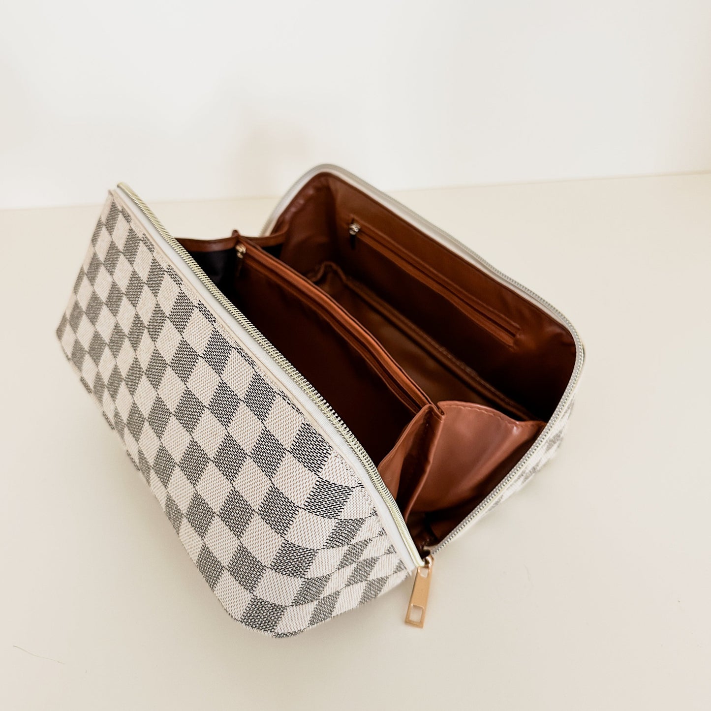 Checkered pattern zippered toiletry case zippers open and lays completely flat